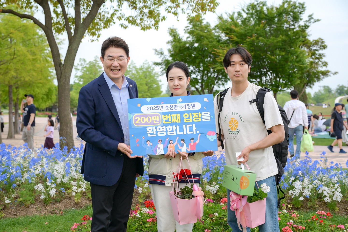 1 노관규 순천시장이 서울에서 방문한 200만 번째 관람객 부부와 함께 기념 사진을 촬영하고 있다.jpeg 이미지입니다.