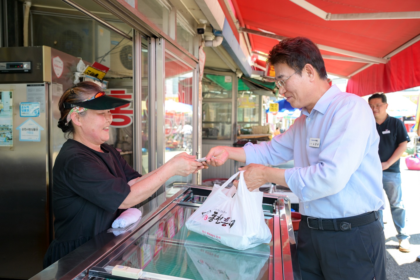 24일 노관규 순천시장이 역전시장을 방문해 식품을 구입 후 민생회복 소비쿠폰으로 결제를 하고 있다.jpg 이미지입니다.